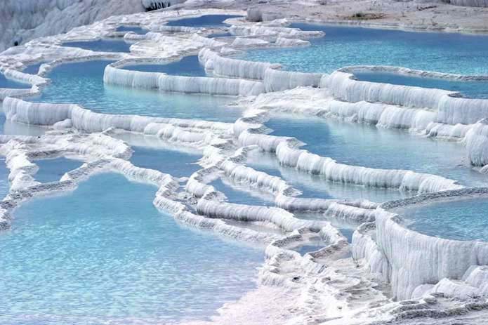 Limestone is what gives the hot springs their white colour. Image via Distractify.