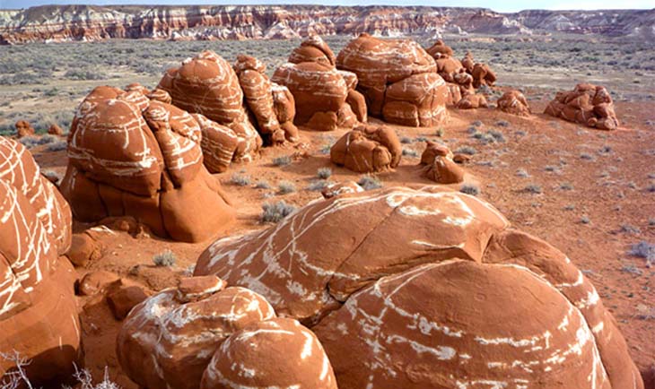 Rounded red boulders with white cross-banding. Photo via the American Southwest